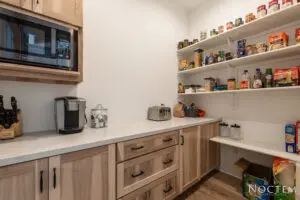 Pantry area with microwave oven number of items on shelves