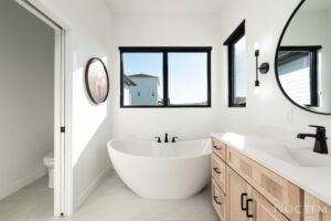 Zoom in view of a bathtub, a mirror and windows