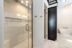 Bathroom with a bathtub and glass door separation