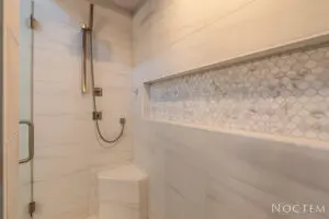 A wall with marbles tiles and a water shower pipe