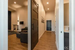 Wooden flooring with a black door and wall frames