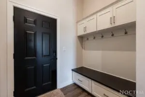 Black door with side cupboards in white and a platform