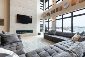 Hall with grey sofas, tv on wall and fire area under tv
