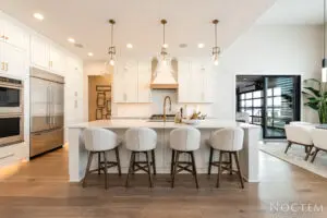 A kitchen with white cabinets and a bar in it