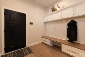 A room with a black door and white cabinets.