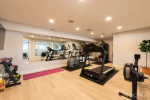 A gym with many different machines and mirrors