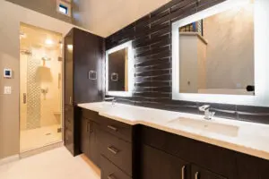 A bathroom with two sinks and a large mirror.