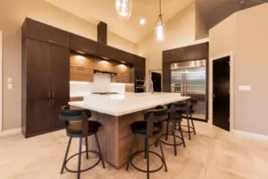 A kitchen with a large island and black chairs.