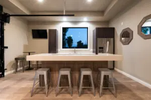 A room with four stools and a television.