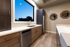 A kitchen with a sink, dishwasher and refrigerator.