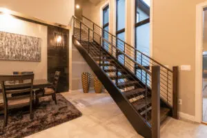 A staircase with metal railing and black steps.