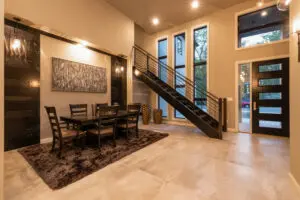 A dining room with a table and chairs, a staircase leading to the second floor.