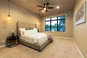 A bedroom with a large bed and ceiling fan.