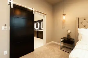 A bedroom with a black sliding door and beige walls.