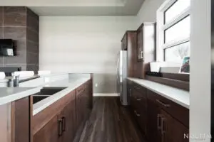 A kitchen with wooden cabinets and white counters.