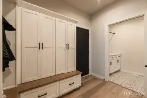 A white room with wooden floors and cabinets.