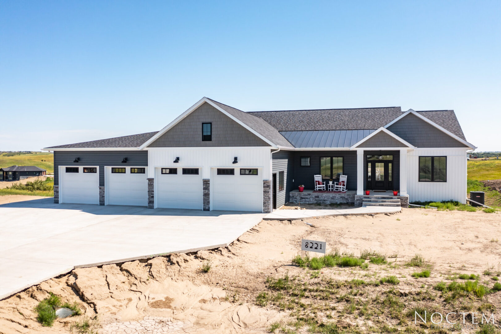 Gray house with white trim and three garage doors.