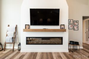 Modern fireplace with tv and wood mantle.