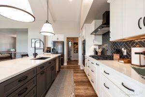 Modern kitchen with white cabinets and black accents.