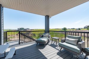 Deck with two chairs and a table overlooking a field.