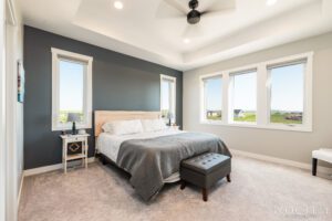 Modern bedroom with large windows and bed.