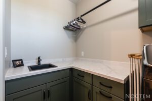 Green cabinets with black sink and countertop.