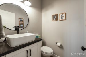 Modern bathroom with white sink and toilet.