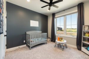 Grey nursery with crib and window view.