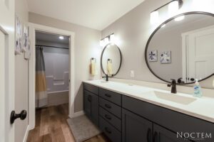 Modern bathroom with double vanity and mirrors.